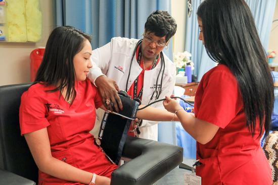 Students and teacher training how to take blood pressure